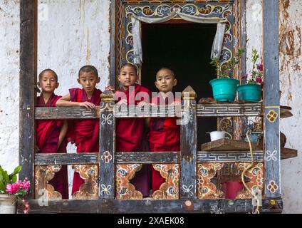 Bhutanische Novizen Mönche auf dem Balkon in Nyenzer Lhakhang, Thedtsho Gewog, Wangdue Phodrang, Bhutan Stockfoto