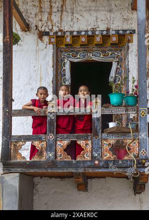 Bhutanische Novizen Mönche auf dem Balkon in Nyenzer Lhakhang, Thedtsho Gewog, Wangdue Phodrang, Bhutan Stockfoto