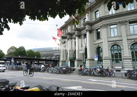 Eine geschäftige Straße mit einem großen Gebäude im Hintergrund. Es gibt viele Fahrräder, die am Straßenrand geparkt sind Stockfoto