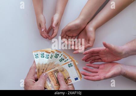 Hände von jungen und alten Familienmitgliedern, die 50-Euro-Banknoten auf weißem Hintergrund kostenlos wünschen Stockfoto