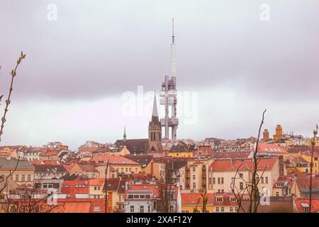 Blick auf den Zizkov-Turm mit Wolken und Häuser mit Dächern in Rot- und Grautönen, ungewöhnliche Aussicht vom Vitkov-Hügel Stockfoto