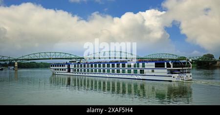 Esztergom, Ungarn 22-05-24. Das Passagier-Kreuzfahrtschiff Swiss Pearl segelt entlang der Donau-Hängebrücke im Hintergrund. Stockfoto