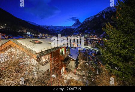 Schneebedeckte Dächer von Zermatt in den Schweizer Alpen im Winter bei Nacht - idyllische Landschaft mit Holzchalets in einem berühmten Skigebiet, das vom M überragt wird Stockfoto