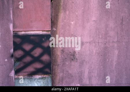 Wand mit alter und schmutziger rosa Farbe mit Rissen für Hintergrund und Inspiration Stockfoto