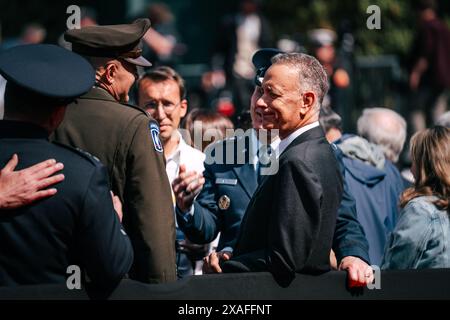 Colleville-sur-Mer, Frankreich. Juni 2024. Der US-amerikanische Schauspieler und Regisseur Tom Hanks, Right, begrüßt den Veteranen des Militärs während einer Veranstaltung auf dem amerikanischen Friedhof der Normandie am 6. Juni 2024 in Colleville-sur-Mer, Frankreich. Biden schloss sich anderen führenden Persönlichkeiten der Welt an, um den 80. Jahrestag des D-Day zu feiern. Quelle: Sgt. Landon Carter/US Army Photo/Alamy Live News Stockfoto