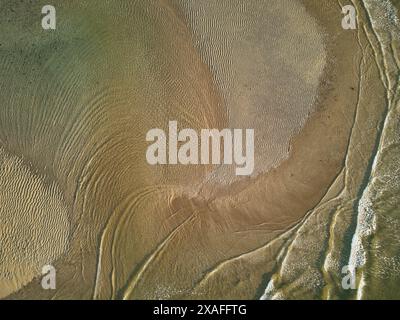 Ein Blick aus der Vogelperspektive direkt nach unten und zeigt Wellen, die um eine Sandbank in der Mündung des Flusses Avon bei Ebbe, Devon, Großbritannien, wehen. Stockfoto