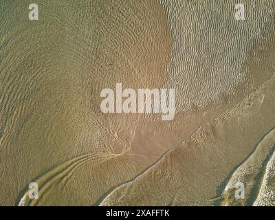 Ein Blick aus der Vogelperspektive direkt nach unten und zeigt Wellen, die um eine Sandbank in der Mündung des Flusses Avon bei Ebbe, Devon, Großbritannien, wehen. Stockfoto