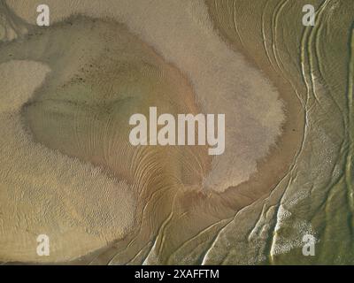 Ein Blick aus der Vogelperspektive direkt nach unten und zeigt Wellen, die um eine Sandbank in der Mündung des Flusses Avon bei Ebbe, Devon, Großbritannien, wehen. Stockfoto