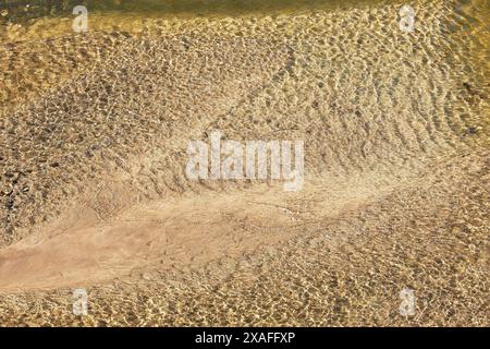 Sonnendurchflutete Wellen auf der Oberfläche des flachen Wassers im Hafen von Boscastle, der bei Ebbe an der Atlantikküste von Cornwall, Großbritannien, zu sehen ist. Stockfoto