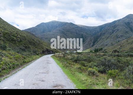 Bergige Landschaft mit einer unbefestigten Straße in den kalten Bergen Kolumbiens an einem bewölkten Tag mit reichlich Nebel Stockfoto