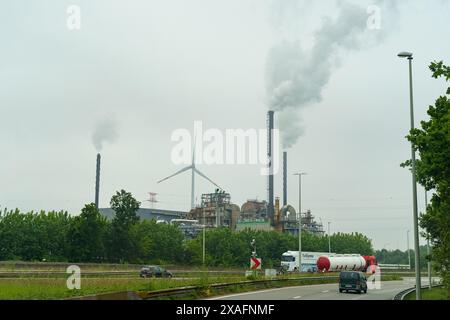 Gent, Belgien - 22. Mai 2023: Rauch aus einer Fabrik in der Nähe einer stark befahrenen Autobahn, was zu Umweltverschmutzung und Umweltproblemen führt. Stockfoto