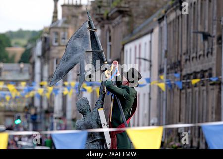 Hawick, Großbritannien, 6. Juni 2024: Kornett Ryan Nichol trägt seine rote Schärpe und grüne Jacke Krawatten blau und gelb zum Horse Memorial. Hawick Common Riding ist das erste der jährlichen Grenzveranstaltungen und feiert die Gefangennahme einer englischen Flagge von einer Raiding Party im Jahr 1514 durch die Jugend von Hawick in Hornshole und den alten Brauch, auf den Märschen oder Grenzen des gemeinsamen Landes zu reiten. Hawick Common Riding Principals 2024 Cornet Ryan Nichol Cornets Lass, Kirsty McAllan Euan E. Robson, (Cornet 2023), rechts. Greig Middlemass, (Cornet 2022), Linksmann. Vater, Shane Coltman Stockfoto