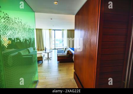 Wunderschöner Blick auf ein luxuriöses Resort-Zimmer mit moderner Einrichtung und Meerblick durch große Fenster, mit einer Dusche mit Glaswänden auf der linken Seite, A Stockfoto