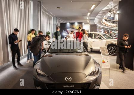 Eine Gruppe von Kunden wird beobachtet, wie sie ein schlankes Mazda MX5 Cabriolet in einem Händlerbetrieb in Belgrad genau inspizieren. Die Mazda5, die Mazda Premacy in so Stockfoto