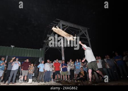 Der Teilnehmer schleudert beim jährlichen Nutria Rodeo in Louisiana einen toten Nutria Werf beim Wettbewerb „Nutria Werft“, bei dem die Jagd auf das invasive Nagetier gefördert wird. Stockfoto