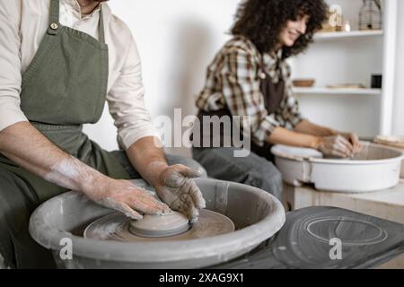 Mann und Frau Töpfer Formen Ton auf Töpferrad im Atelier. Kreativer Prozess, handwerkliches Können und handgemachte Keramik. Stockfoto