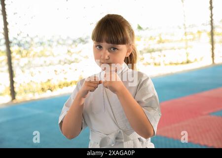 Ein Mädchen in Kimono, das draußen Karate auf Tatami übt Stockfoto