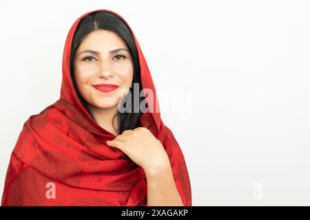 Porträt einer Frau mit rotem Schal im Studio. Junge Frau aus dem Nahen Osten, weißer Hintergrund Stockfoto