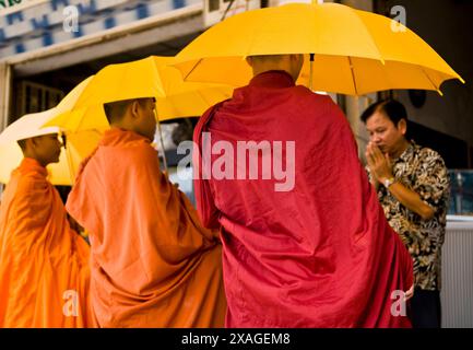 Buddhistische Mönche sammeln Almosen in den frühen Morgenstunden in Phnom Penh, Kambodscha. Stockfoto