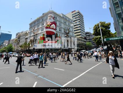 Fußgänger überqueren die Queens Street entlang der Victoria Street in Auckland, Neuseeland. Stockfoto