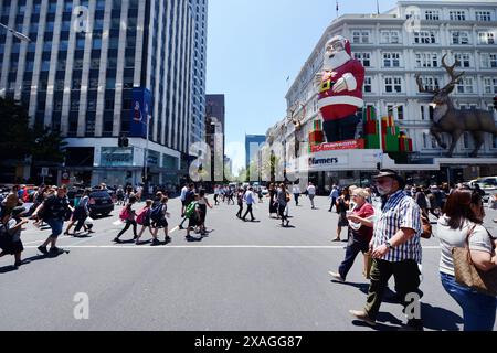 Fußgänger überqueren die Queens Street entlang der Victoria Street in Auckland, Neuseeland. Stockfoto