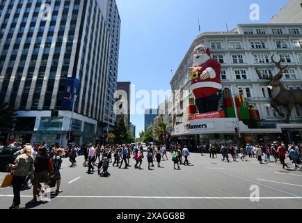 Fußgänger überqueren die Queens Street entlang der Victoria Street in Auckland, Neuseeland. Stockfoto