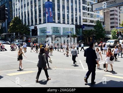 Fußgänger überqueren die Queens Street entlang der Victoria Street in Auckland, Neuseeland. Stockfoto