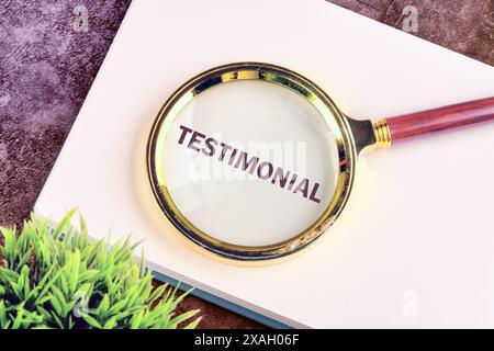 TESTIMONIAL geschrieben durch eine Lupe auf einem leeren Notizblock Stockfoto