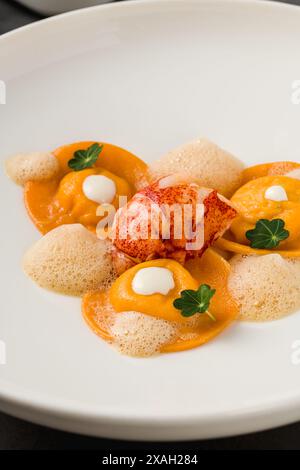 Ravioli mit gegrillten Garnelen auf einem weißen Porzellanteller Stockfoto