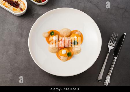 Ravioli mit gegrillten Garnelen auf einem weißen Porzellanteller Stockfoto