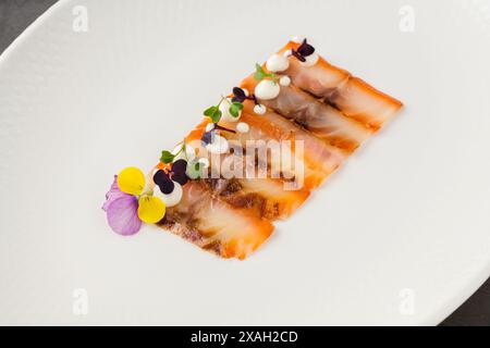 Geräucherter Fisch, Pastrami oder Speck auf einem weißen Porzellanteller Stockfoto