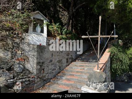 Ein eisernes Kreuz und ein Madonnelle-Schrein für Maria am Fuße der Stufen, die zum Kloster der Kapuzinerbrüder in Monterosso, Cinque Terre, Italien führen Stockfoto