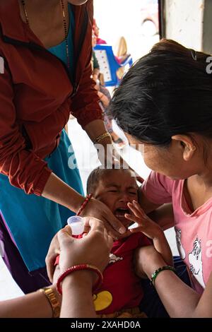 Eine Mutter mit ihrem kranken und schwachen Baby besucht Samudayik Swastha Ikai, eine Gemeindegesundheitsklinik für eine Untersuchung im Dorf Shyangdi. Chitwan, Nepal. Stockfoto