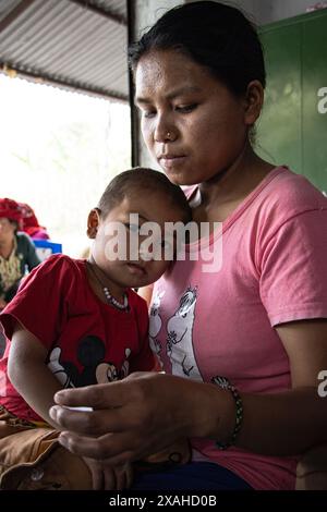 Eine Mutter mit ihrem kranken und schwachen Baby besucht Samudayik Swastha Ikai, eine Gemeindegesundheitsklinik für eine Untersuchung im Dorf Shyangdi. Chitwan, Nepal. Stockfoto