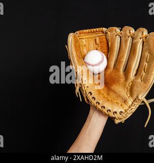 Baseballspielerhand mit Handschuh gefangenem Ball, isoliert auf Schwarz. Baseball, Sport, Meisterschaft Stockfoto