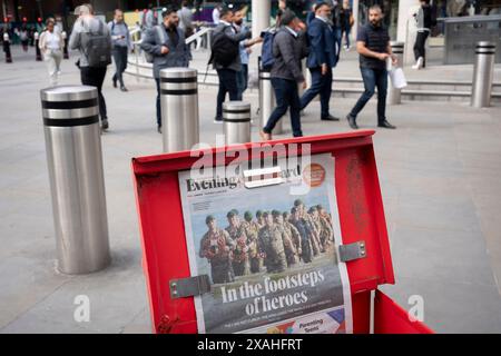Mitglieder der Öffentlichkeit gehen vorbei an der Evening Standard-Schlagzeile, die den 80. Jahrestag der Landung am D-Day am 6. Juni 2024 in der Liverpool Street Station in der City of London, dem Finanzviertel der Hauptstadt, in London, berichtet. Besitzer des Evening Standard haben angekündigt, dass der Titel der Daily London bald nach 97 Jahren nicht mehr täglich veröffentlicht wird. Stockfoto