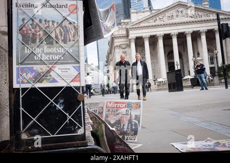 Mitglieder der Public Walk Past the Evening Standard News Schlagzeile, die über den 80. Jahrestag der Landung des D-Day in der City of London, dem Finanzviertel der Hauptstadt, am 6. Juni 2024 in London, England berichtet. Besitzer des Evening Standard haben angekündigt, dass der Titel der Daily London bald nach 97 Jahren nicht mehr täglich veröffentlicht wird. Stockfoto
