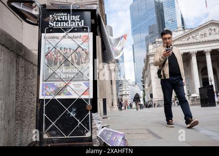 Mitglieder der Public Walk Past the Evening Standard News Schlagzeile, die über den 80. Jahrestag der Landung des D-Day in der City of London, dem Finanzviertel der Hauptstadt, am 6. Juni 2024 in London, England berichtet. Besitzer des Evening Standard haben angekündigt, dass der Titel der Daily London bald nach 97 Jahren nicht mehr täglich veröffentlicht wird. Stockfoto