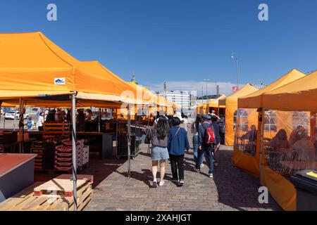 Touristen, die an einem hellen Sommertag auf dem Marktplatz von Helsinki spazieren gehen Stockfoto