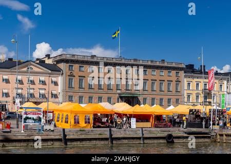 Touristen, die an einem hellen Sommertag auf dem Marktplatz von Helsinki spazieren gehen Stockfoto