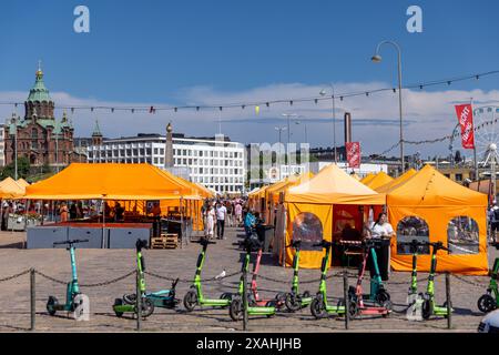 Touristen, die an einem hellen Sommertag auf dem Marktplatz von Helsinki spazieren gehen Stockfoto