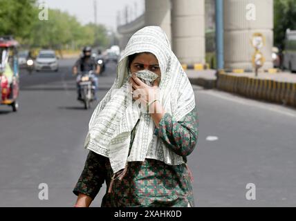 NOIDA, INDIEN – 5. JUNI: Besucher trotzen der Hitzewelle an einem heißen Sommernachmittag, da die Temperatur im Delhi-NCR am 5. Juni 2024 in Noida, Indien, steigt. Mehrere Gebiete in Delhi, darunter Chanakyapuris Sanjay Camp Area und die Geeta Colony Area, die mit akutem Wassermangel konfrontiert sind. In der glühenden Hitze warten die Menschen in langen Warteschlangen, in der Hoffnung, mindestens einen Eimer zu füllen, während Tanker kommen und gehen, ohne die große Bevölkerung in den Kolonien angemessen zu bedienen. (Foto: Sunil Ghosh/Hindustan Times/SIPA USA ) Stockfoto