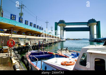 Samcheok City, Südkorea - 18. Mai 2024: Das Samcheok Port Raw Fish Center mit Booten in der Nähe und dem Tsunami Safety Tower im Hintergrund, Stockfoto