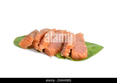 Das Bild zeigt Lachsstücke, die auf Salatblättern liegen. Stockfoto