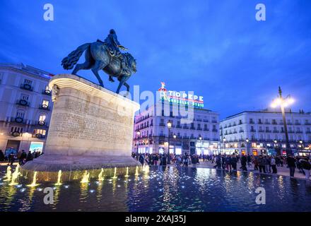 Die Statue von König Carlos III. Mit dem berühmten Tio Pepe-Werbeschild im Hintergrund in der Puerta del Sol, Madrid, Spanien. Stockfoto