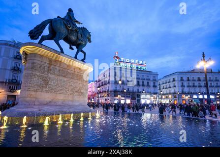 Die Statue von König Carlos III. Mit dem berühmten Tio Pepe-Werbeschild im Hintergrund in der Puerta del Sol, Madrid, Spanien. Stockfoto