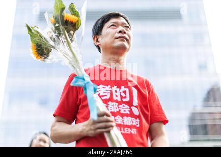 Wuhan, China. Juni 2024. Ein Vater hält Blumen in der Hand, während er vor der Aufnahmeprüfung des National College, auch bekannt als Gaokao, an der No.2 High School, einer der angesehensten Schulen der Stadt, wartet. Die Studenten verbringen Monate damit, sich auf die jährliche Prüfung vorzubereiten, und die Ergebnisse bestimmen den Bildungsweg und die zukünftigen Berufsaussichten der Schüler. Insgesamt werden 13,42 Millionen Studenten an drei Tagen an den Prüfungen teilnehmen. Quelle: SOPA Images Limited/Alamy Live News Stockfoto