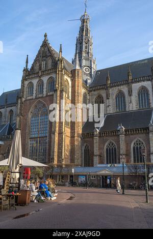 Kathedrale von St. Bavo, Haarlem, Niederlande mit einigen der berühmten Türme und umliegenden Cafés im Freien. Die Leute genießen die Sonne auf dem Platz. Stockfoto