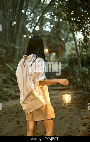 Frau mit einer Laterne im Wald Stockfoto