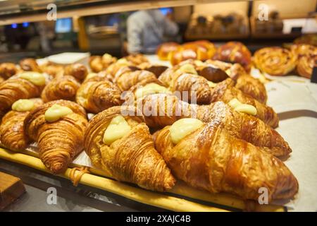 Nahaufnahme - Auswahl an frisch gebackenen Croissants, die an der Theke, auf dem Markt, im Café oder in der Bäckerei verkauft werden. Dessert, Gebäck, Frühstück, süßes Essen und Stockfoto